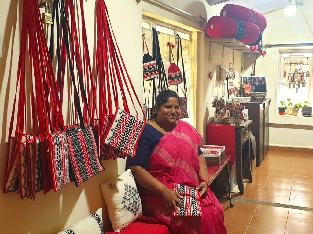 Epsheba in the Shalom Ooty store with some bags that she has sewn
