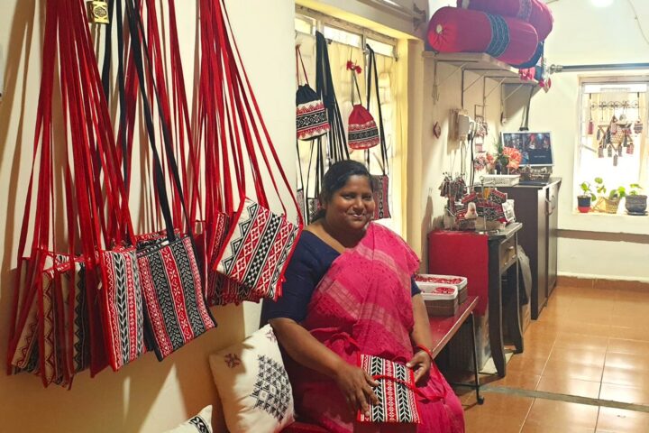 Epsheba in the Shalom Ooty store with some bags that she has sewn
