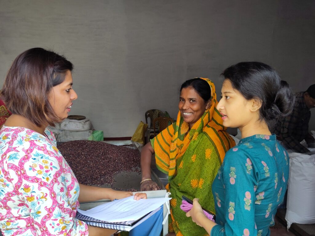 Kakuli sorts rice as she speaks with Women on Wings Disha Rathour