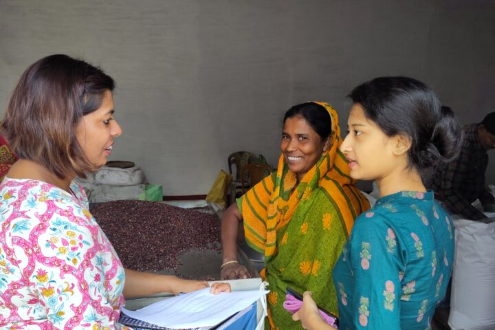 Kakuli sorts rice as she speaks with Women on Wings Disha Rathour