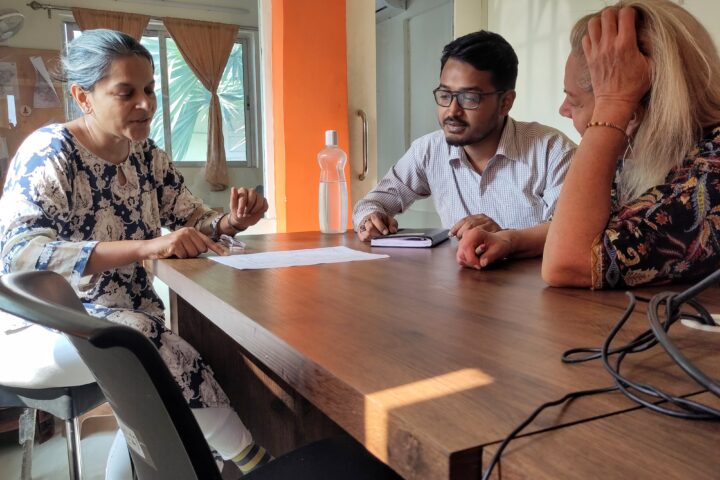 Three people discussing logistics of moving and handling farmer's products in a processing plant